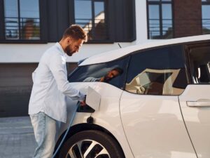 Ein Mitarbeiter nutzt das Angebot zum Laden seines Elektroautos am Arbeitsplatz, da das Unternehmen im Bereich der Elektromobilität die Ladeinfrastruktur ausgebaut hat.