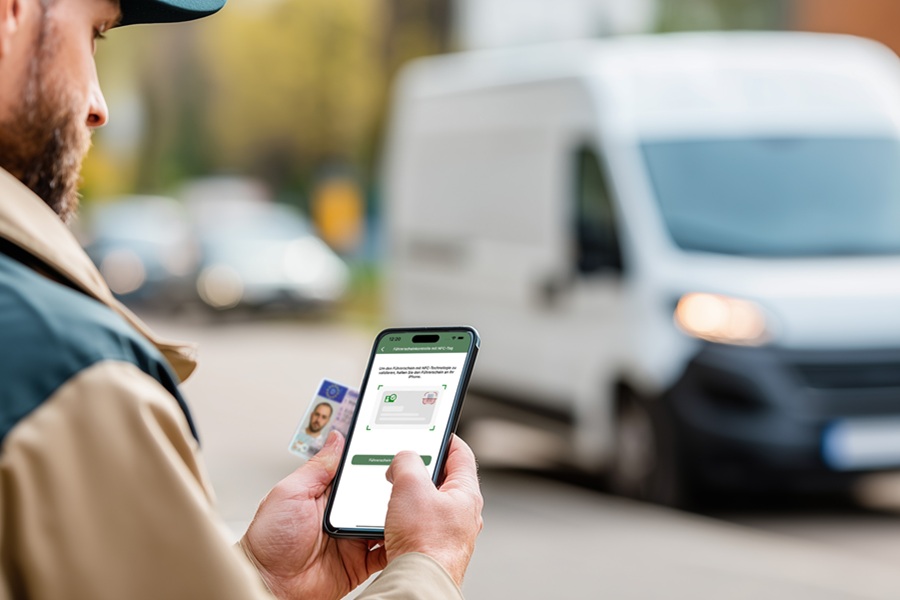 Ein Mitarbeiter im Fuhrpark hält ein Smartphone in der Hand. Darauf ist eine App mit der digitalen Führerscheinkontrolle geöffnet. Ein Symbolbild für die Vorteile der digitalen Führerscheinkontrolle gegenüber dem Führerscheinkontrolle Arbeitgeber Muster.
