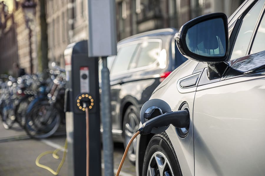 Ein Elektroauto lädt an einer öffentlichen Ladesäule. Unternehmen können damit ihren Fuhrpark elektrifizieren. Fleethouse unterstützt dabei mit moderner Fuhrparkmanagement Software für effiziente Planung und Ladeinfrastruktur.