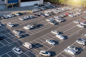 Großer Firmenparkplatz mit vielen Fahrzeugen. Mit Fleethouse Fuhrparksoftware gelingt eine digitale Fuhrparkorganisation für mehr Effizienz, Transparenz und zentrale Steuerung im Unternehmensalltag.