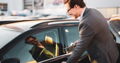 Ein Mann im Anzug öffnet die Tür eines Autos mit einem Lächeln im Gesicht. Auto abonnieren bietet flexible Mobilität ohne langfristige Bindung – ideal für Unternehmen, die ihren Fuhrpark schnell, digital und bedarfsgerecht mit Fleethouse gestalten möchten.