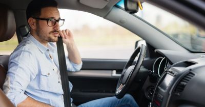 Ein Mann im Dienstwagen legt den Sicherheitsgurt an. Fleethouse unterstützt Unternehmen mit digitaler Fuhrparkmanagement-Software bei der Erstellung und Umsetzung einer modernen Car Policy, insbesondere für E-Fahrzeuge – für klare Regeln, nachhaltige Mobilität und mehr Transparenz im Fuhrpark.