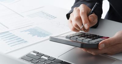 Nahaufnahme einer Person, die mit einem Taschenrechner steuerliche Berechnungen durchführt. Fleethouse bietet Unternehmen Lösungen zur effizienten Versteuerung von Dienstwagen, um steuerliche Vorteile zu nutzen, Kosten zu optimieren und die Verwaltung zu vereinfachen.