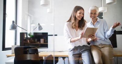 Digitales Fuhrparkmanagement für die effiziente Verwaltung von Fahrzeugen, Wartung und Fuhrparkdaten. Zwei Frauen nutzen ein Tablet, um gemeinsam das digitale Fuhrparkmanagement zu optimieren, die Fahrzeugflotten effizient zu verwalten und Kosten zu senken.