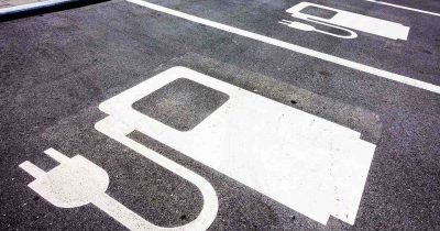 Parkplätze mit Symbolen für das Laden von Elektrofahrzeugen. Fleethouse unterstützt Unternehmen bei der Verwaltung der Kosten für E-Fahrzeuge – von der Ladeinfrastruktur bis zu Betriebsausgaben – für eine effiziente und kostensparende Flottenstrategie im Fuhrparkmanagement.