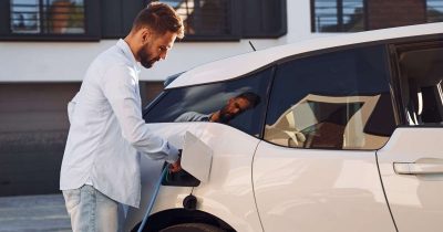 Ladeinfrastruktur Elektromobilität im Unternehmen – Elektroauto laden Ein Mitarbeiter nutzt das Angebot zum Laden seines Elektroautos am Arbeitsplatz, da das Unternehmen im Bereich der Elektromobilität die Ladeinfrastruktur ausgebaut hat.