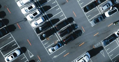 Luftaufnahme eines Parkplatzes mit zahlreichen geparkten Fahrzeugen. Die digitale Fahrzeugverwaltung von Fleethouse optimiert Fuhrparkprozesse, reduziert Kosten und verbessert die Auslastung von Firmenfahrzeugen – für eine effiziente und transparente Flottenorganisation.