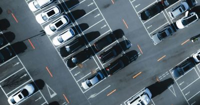 Effiziente Fahrzeugverwaltung für Unternehmen mit Fleethouse zur Optimierung des Fuhrparks und Kostensenkung Luftaufnahme eines Parkplatzes mit zahlreichen geparkten Fahrzeugen. Die digitale Fahrzeugverwaltung von Fleethouse optimiert Fuhrparkprozesse, reduziert Kosten und verbessert die Auslastung von Firmenfahrzeugen – für eine effiziente und transparente Flottenorganisation.