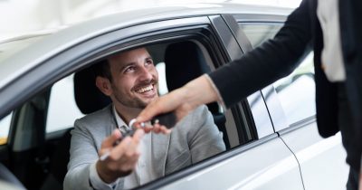 Ein Geschäftsmann sitzt im Auto und erhält den Fahrzeugschlüssel – Symbol für eine einfache und clevere Firmenwagenfinanzierung. Fleethouse bietet digitale Lösungen für Unternehmen, um Firmenwagen effizient und unkompliziert zu finanzieren – ganz ohne Papierkram und langwierige Prozesse.