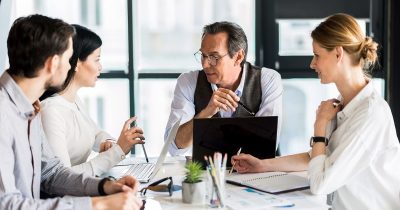 Ein Team bespricht am Konferenztisch die Auslagerung des Fuhrparkmanagements. Fleethouse bietet Entscheidungshilfen und digitale L&ouml;sungen, um das Fuhrpark-Outsourcing effizient, kostensparend und bedarfsgerecht umzusetzen &ndash; individuell abgestimmt auf die Anforderungen moderner Unternehmen.