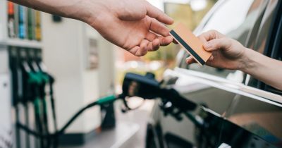 Ein Fahrer reicht eine Tankkarte an einer Tankstelle aus dem Autofenster. Fleethouse bietet Unternehmen ma&szlig;geschneiderte Tankkartenl&ouml;sungen, um Kraftstoffkosten zu optimieren, Ausgaben zu kontrollieren und den Fuhrpark effizient zu verwalten.
