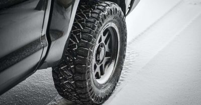 Ein Fahrzeug mit robusten Winterreifen auf einer verschneiten Stra&szlig;e. Winterreifen bieten bessere Traktion und Sicherheit bei kaltem Wetter. Achten Sie darauf, dass Ihr Fuhrpark bei winterlichen Bedingungen optimal ausgestattet ist, um die Sicherheit und Effizienz zu maximieren.